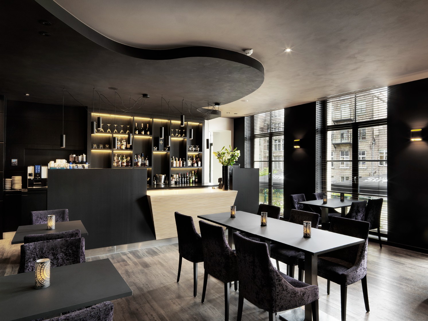 De bar en lounge van Hotel Harmony met open rekken en grote ramen